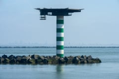 Grüner Leuchtturm mit Helikoper-Platform  im Rotterdamer Hafen